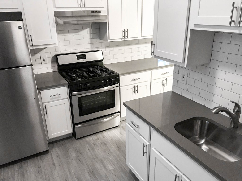 a white kitchen with stainless steel appliances and white cabinets