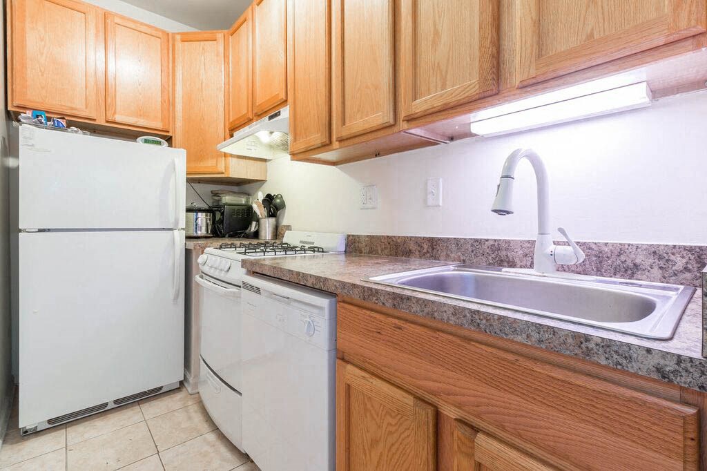 a kitchen with white appliances and wooden cabinets
