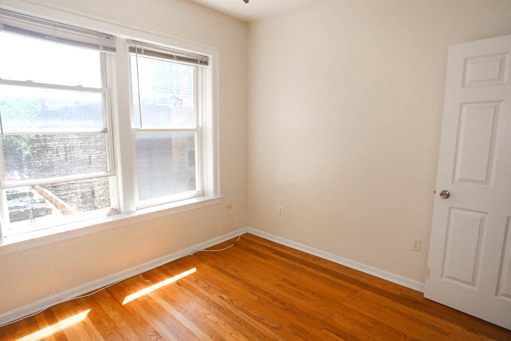 a room with a wooden floor and two windows