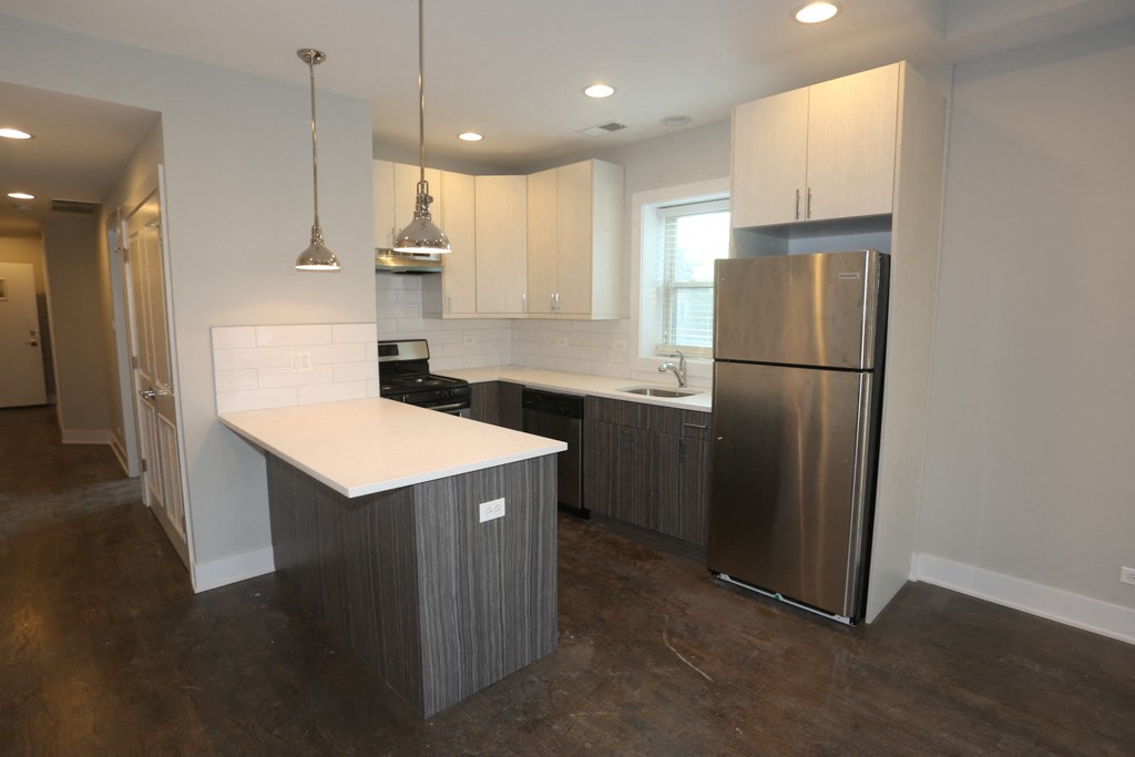 a kitchen with a stainless steel refrigerator and a white counter top