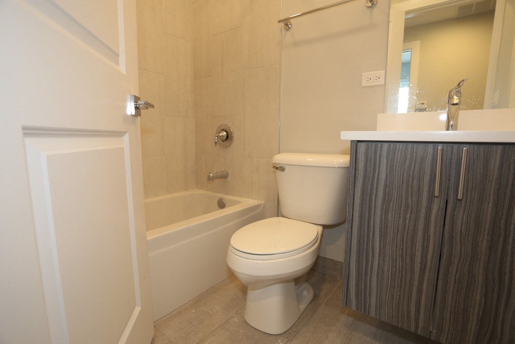 a bathroom with a toilet and a tub and a sink