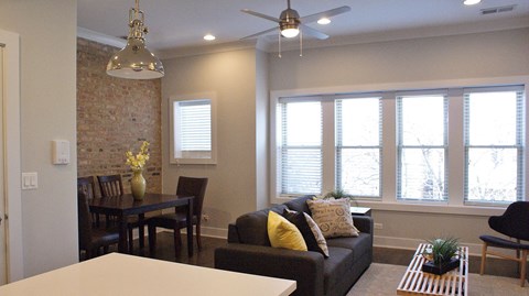 a living room with a couch and a table and a ceiling fan