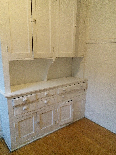 a kitchen counter with white cabinets and drawers
