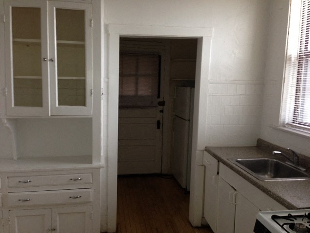 a kitchen with white cabinets and a sink and a door