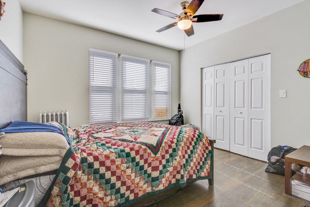 a bedroom with a bed and a ceiling fan