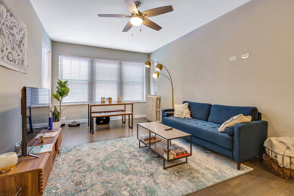 a living room with a blue couch and a ceiling fan
