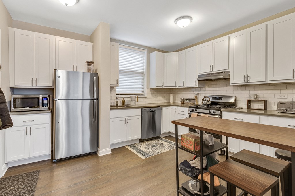 a kitchen with white cabinets and stainless steel appliances