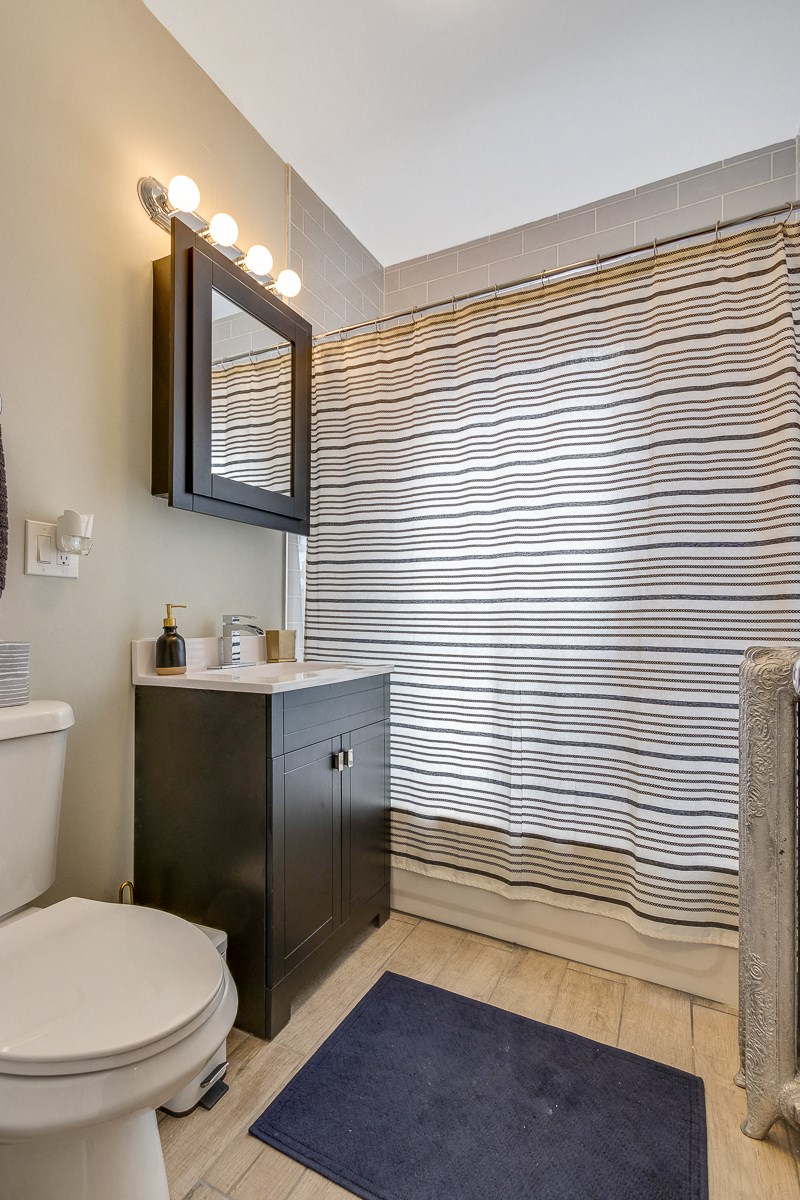 a bathroom with a toilet sink and shower and a mirror