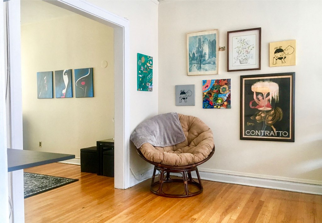 a room with a chair and paintings on the wall