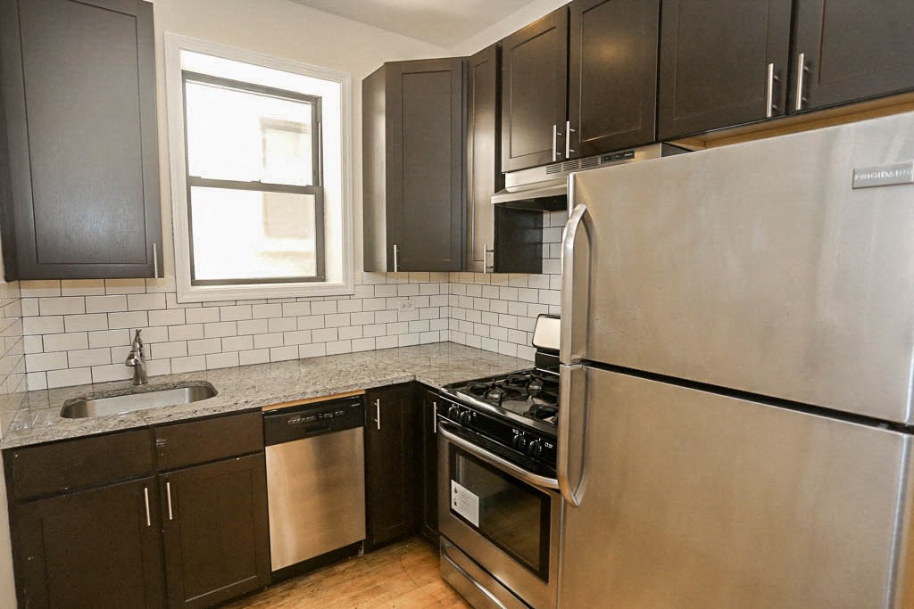 a kitchen with stainless steel appliances and black cabinets