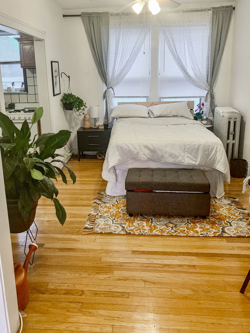 a bedroom with a bed and a trunk on a wood floor