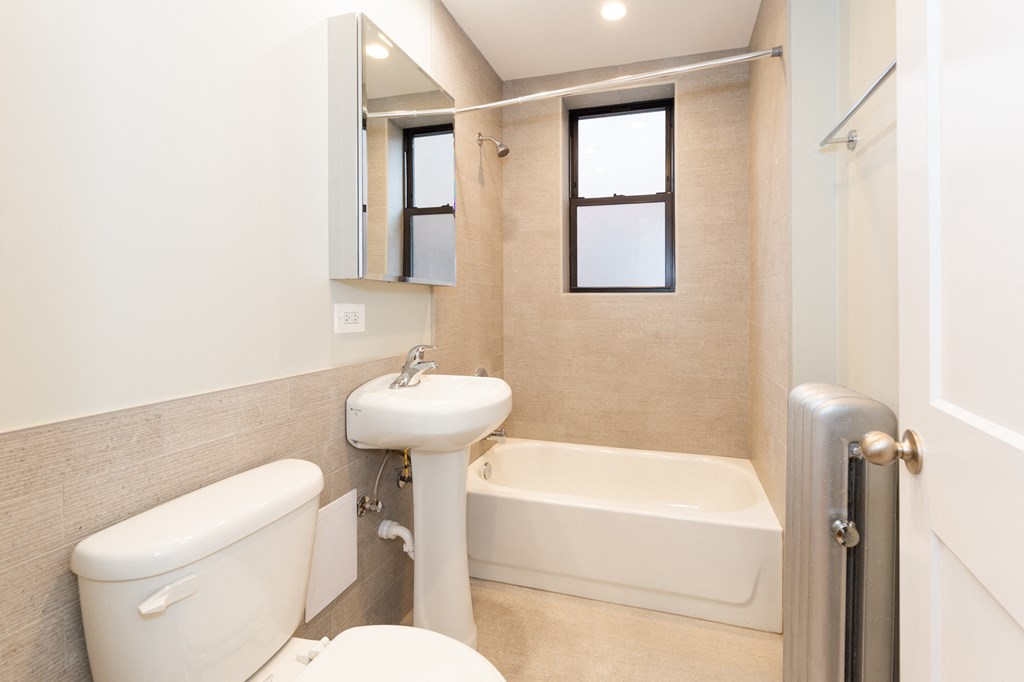 a bathroom with a toilet sink and tub and a mirror