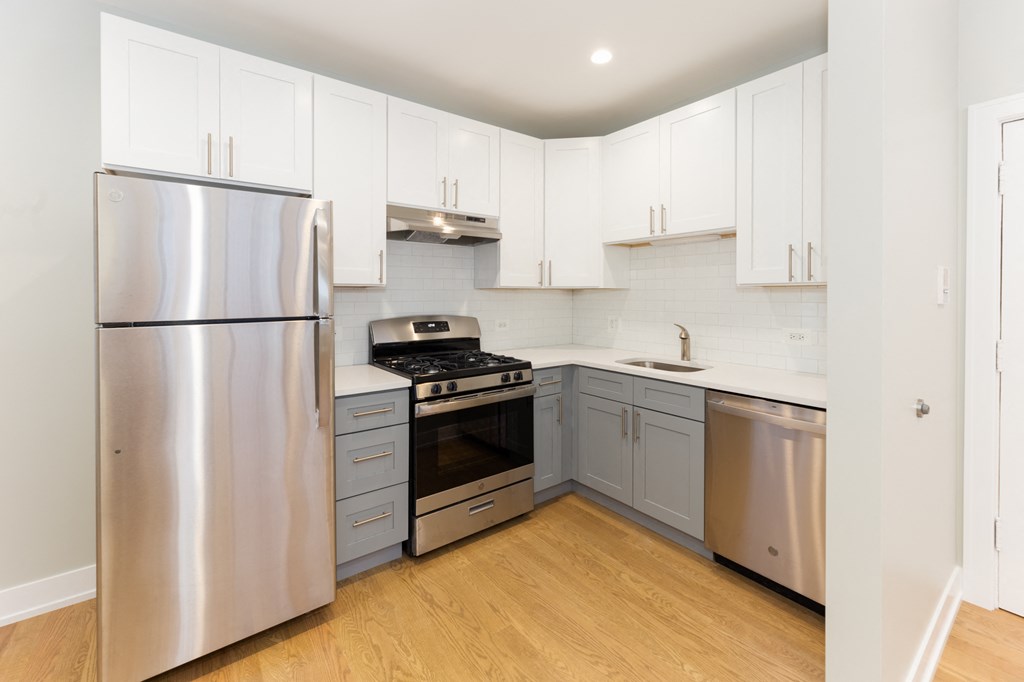 a renovated kitchen with stainless steel appliances and white cabinets