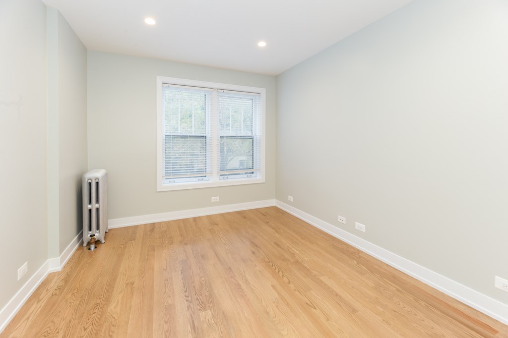 an empty room with wooden floors and a window