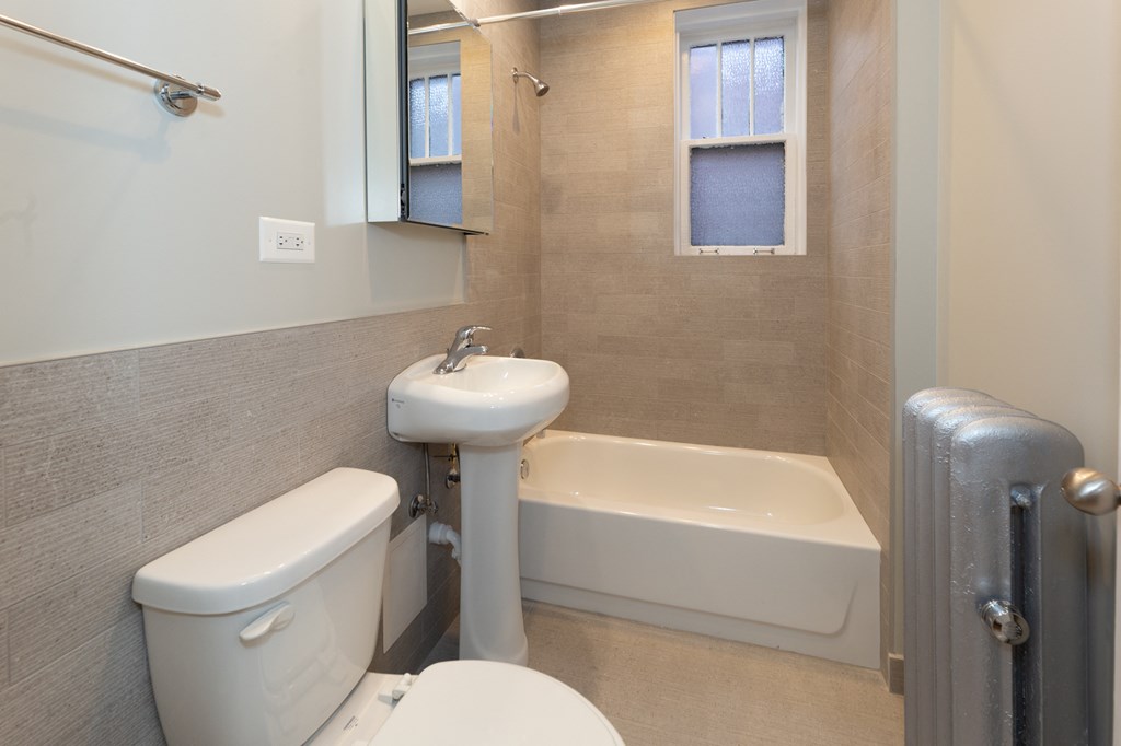 a bathroom with a toilet and a sink and a tub