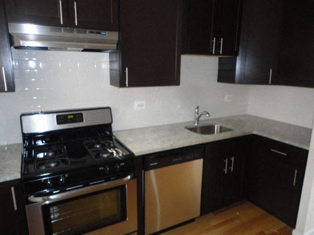 an empty kitchen with a stove and a sink