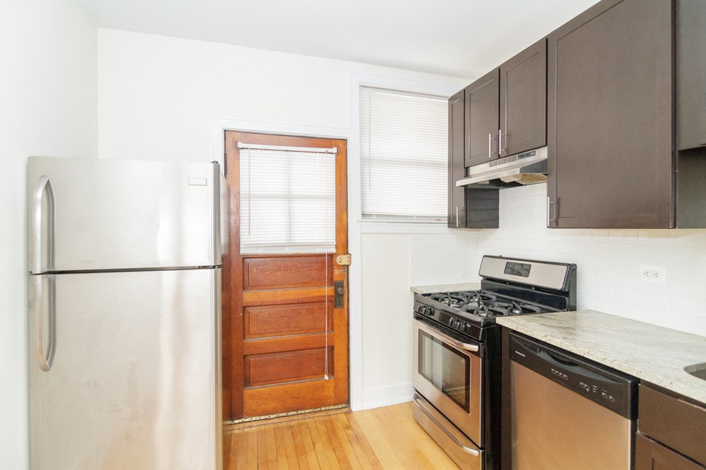 a kitchen with a refrigerator and stove and a door