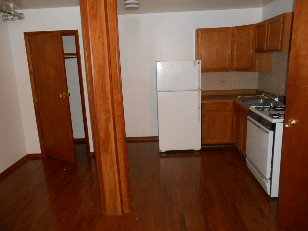 a kitchen with wooden floors and a white refrigerator