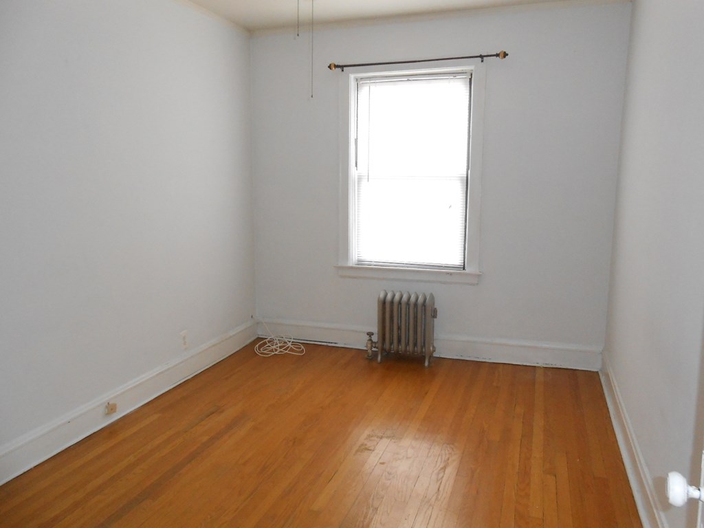 an empty room with a radiator and a window