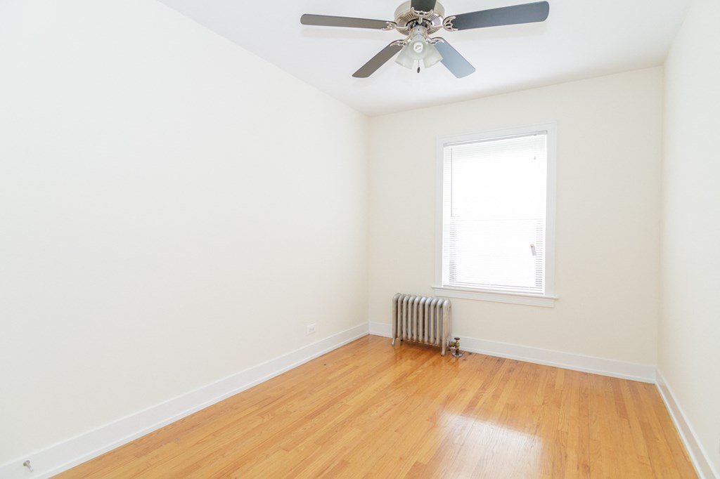 an empty room with white walls and a ceiling fan