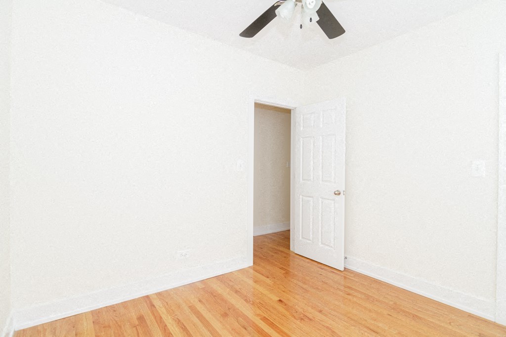 an empty room with a ceiling fan and a door
