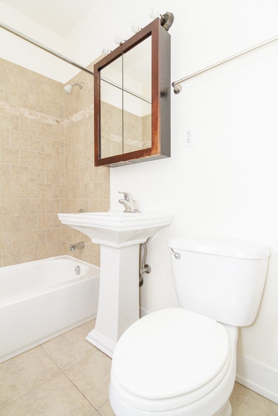 a small bathroom with a toilet sink and tub and a mirror