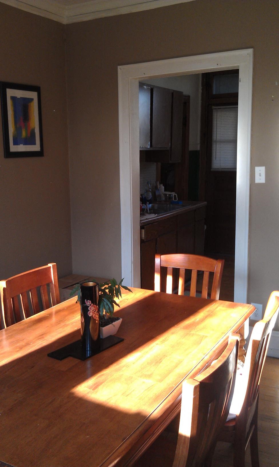a dining room with a wooden table and chairs