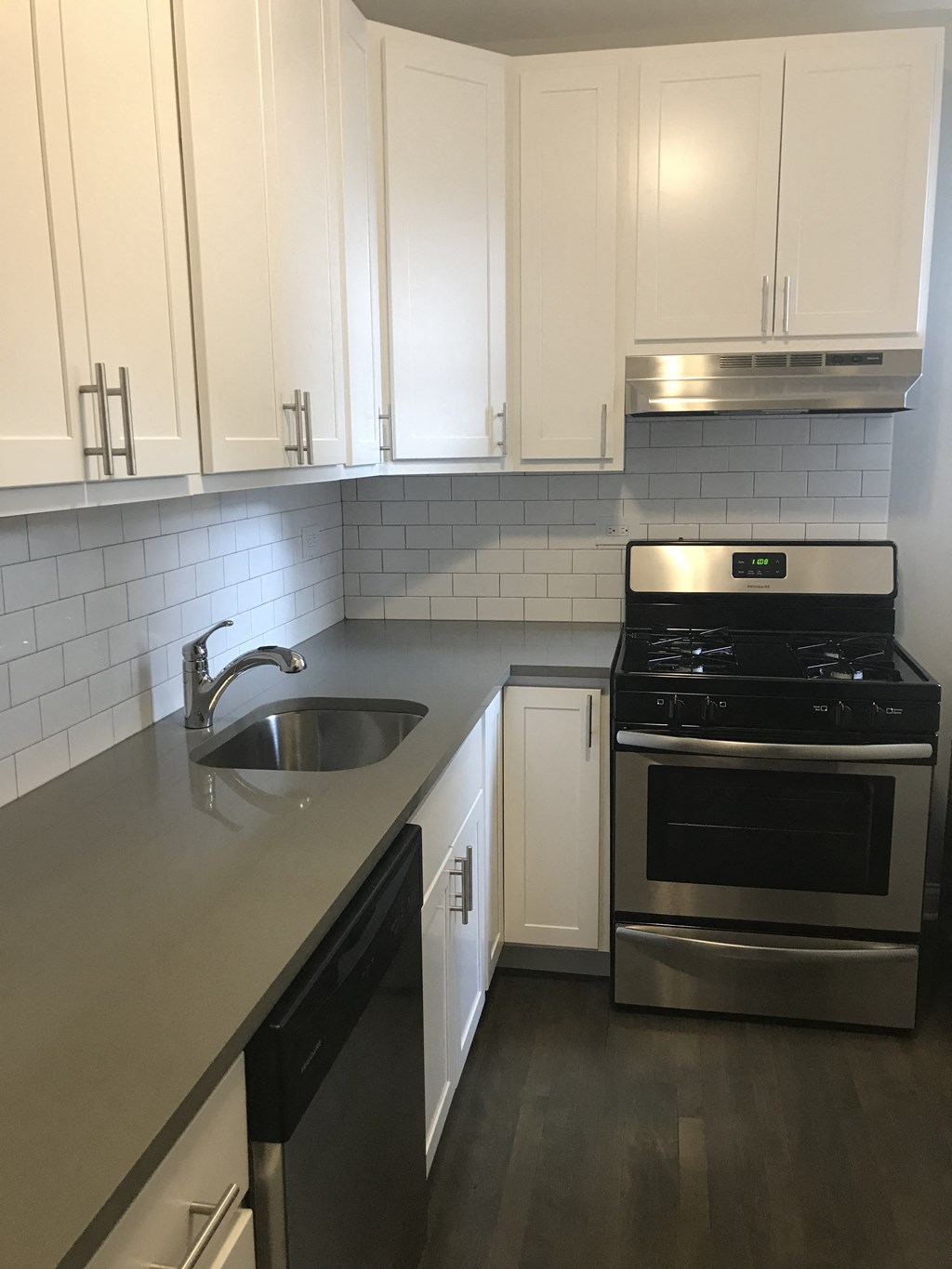 an empty kitchen with white cabinets and a sink