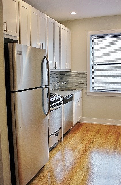 a kitchen with white cabinets and a refrigerator