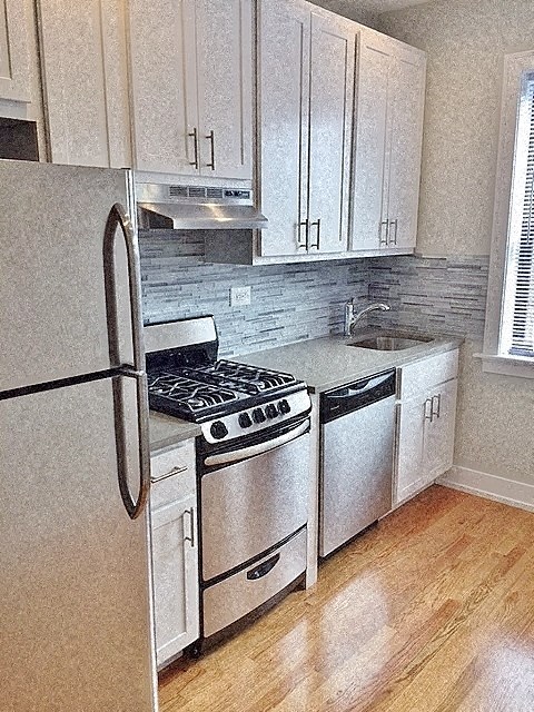 a kitchen with stainless steel appliances and white cabinets