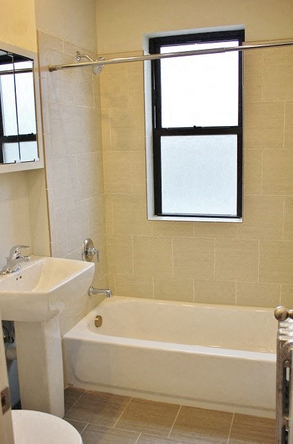 a bathroom with a tub and a sink and a window