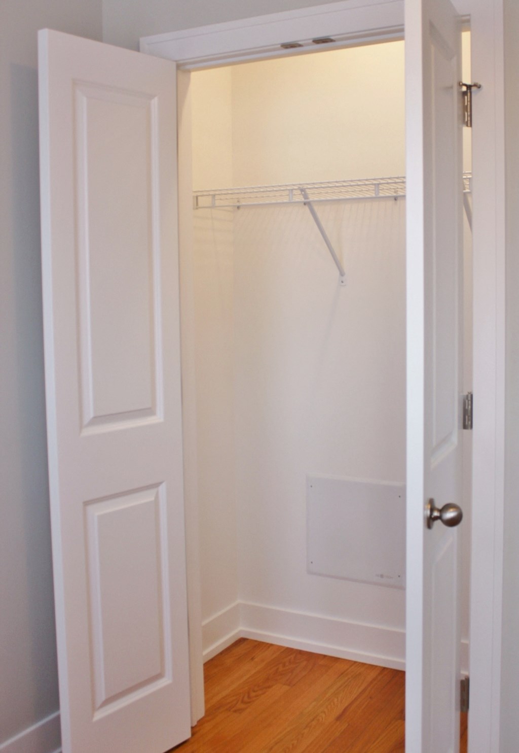 a closet with a white door and a shower in it