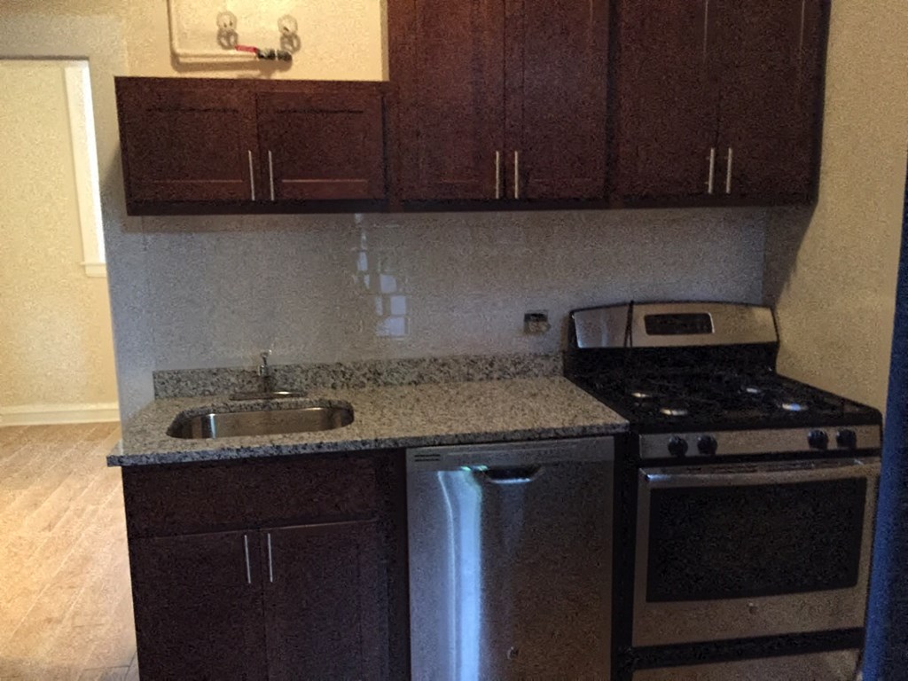 an empty kitchen with a stove and a sink