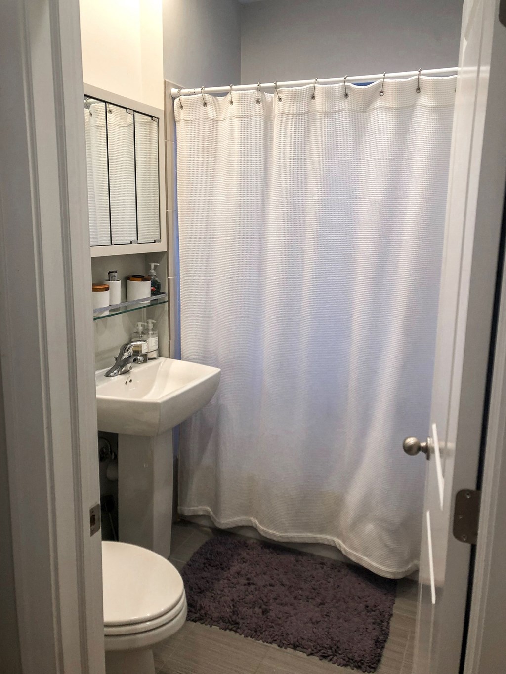 a bathroom with a shower and a sink and a toilet