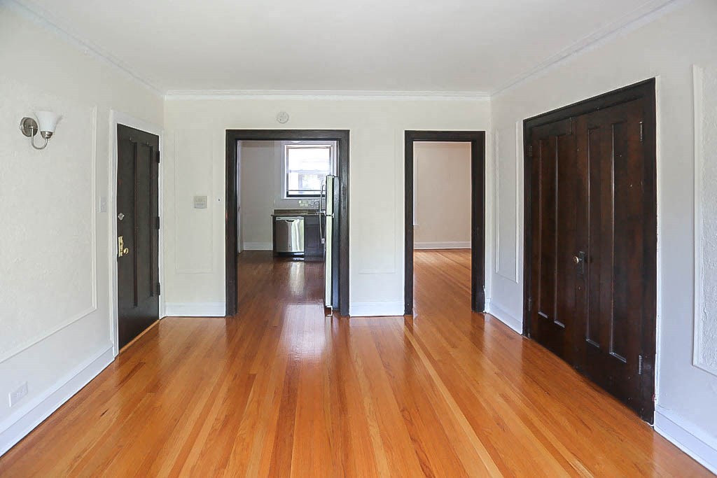 a empty living room with wood floors and doors
