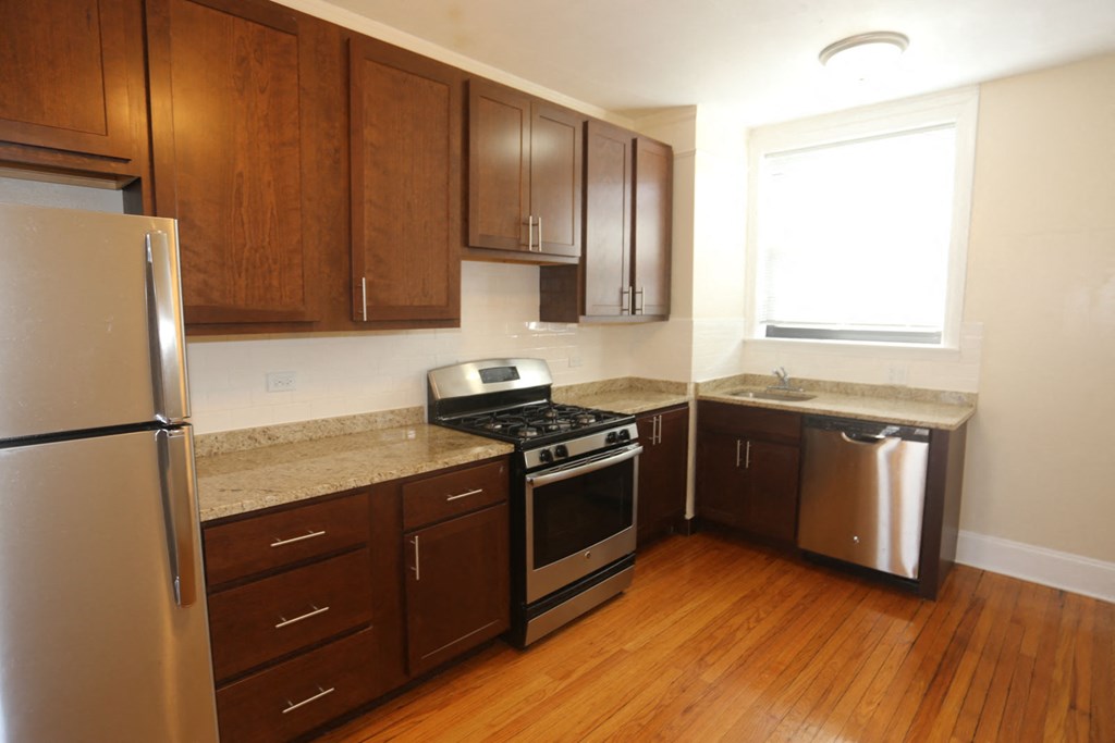 a kitchen with wooden cabinets and stainless steel appliances