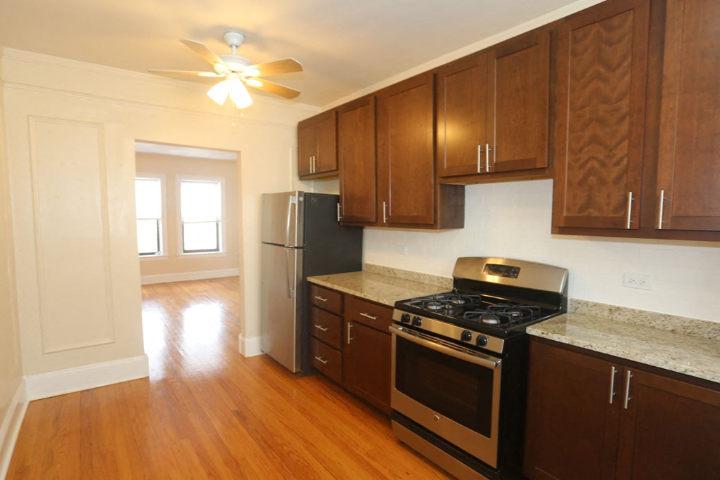 an empty kitchen with wooden cabinets and stainless steel appliances