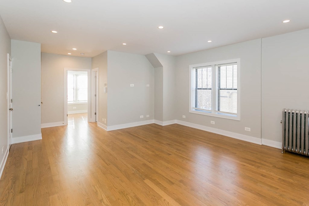 a living room with a hard wood floor and a window