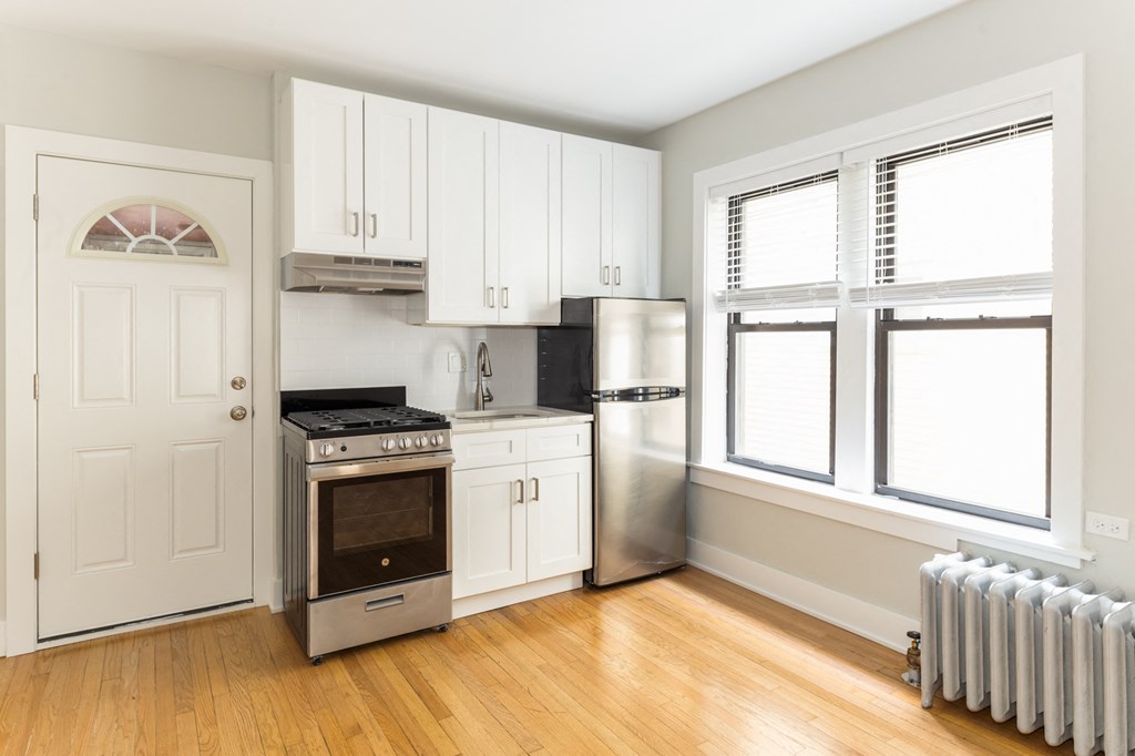 a kitchen with white cabinets and a stove and a refrigerator
