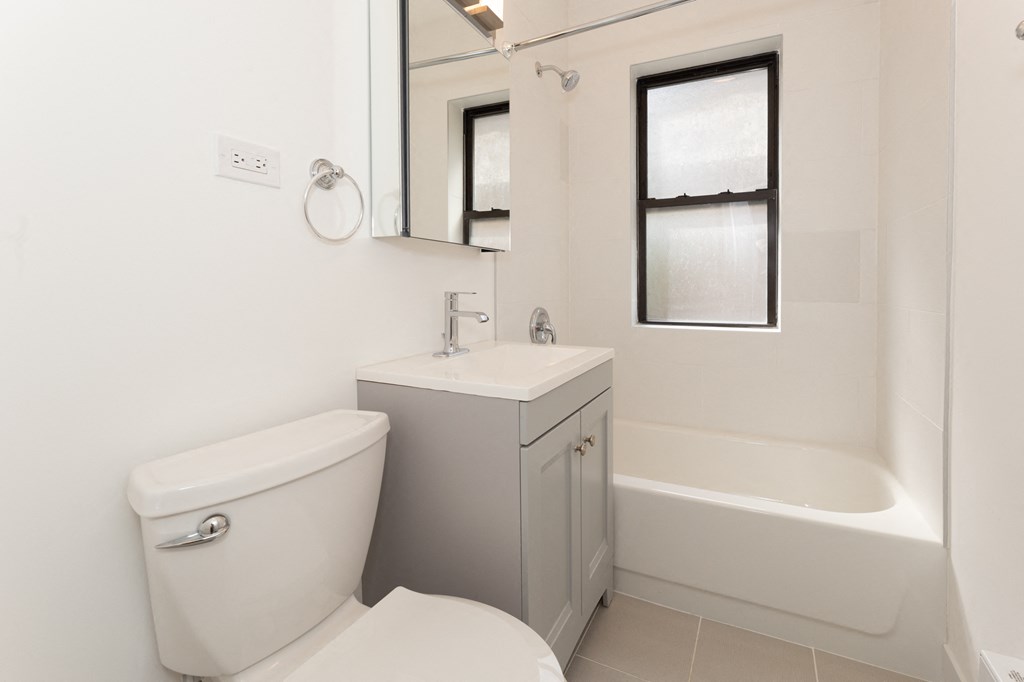 a bathroom with a toilet and a sink and a bath tub
