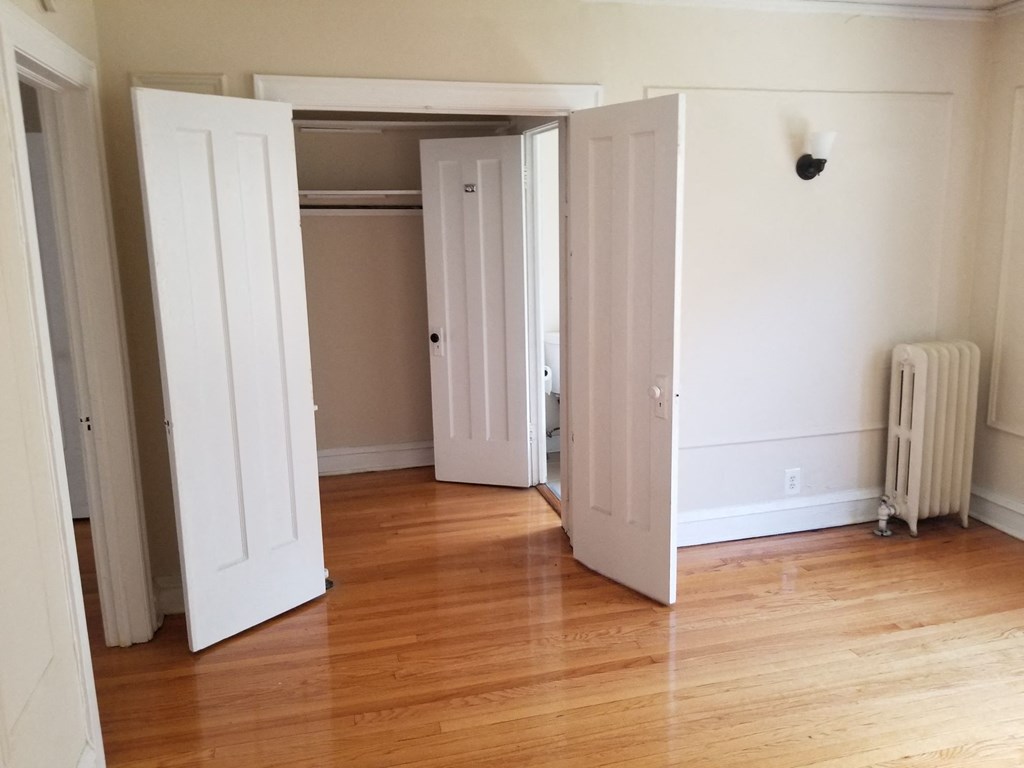a living room with wood floors and white closet doors