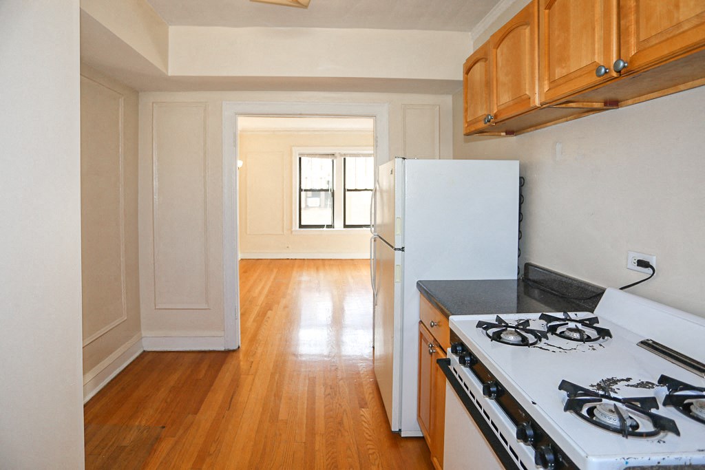 an empty kitchen with a stove and a refrigerator