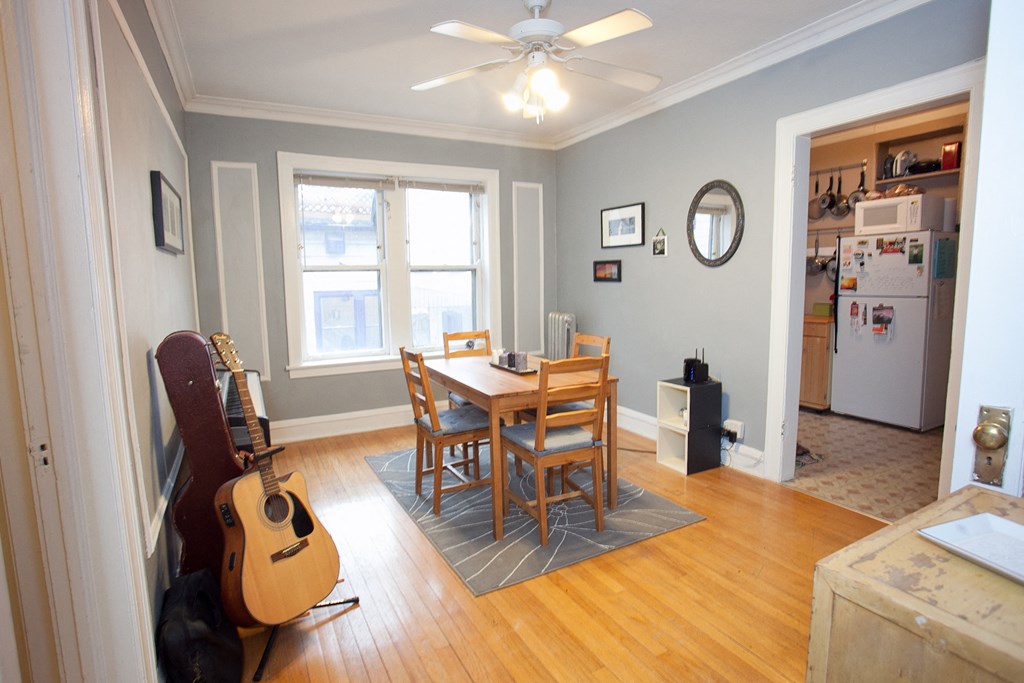 a dining room with a table and chairs and a guitar