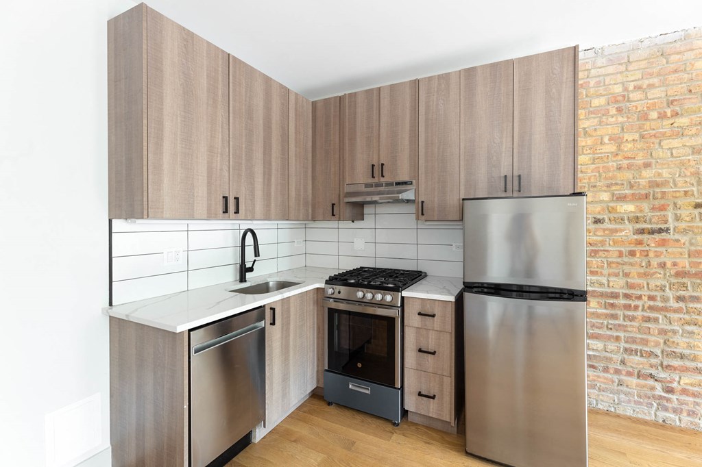 a kitchen with wooden cabinets and a stainless steel refrigerator