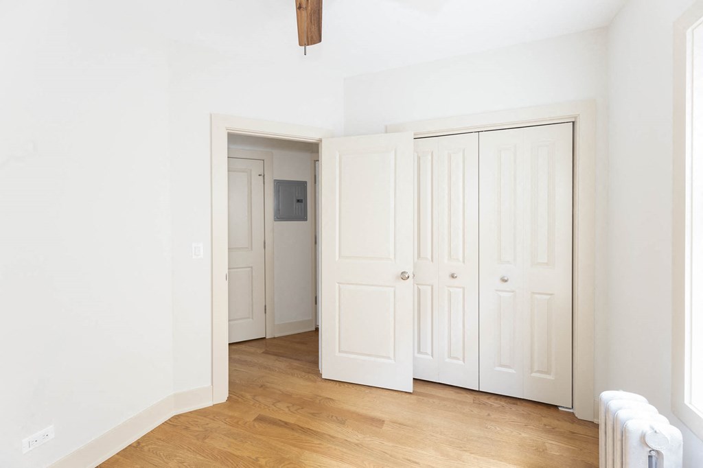 a room with three closets and a wood floor