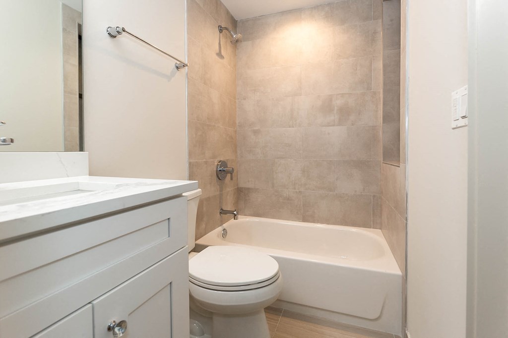 a bathroom with a toilet and a tub and a sink