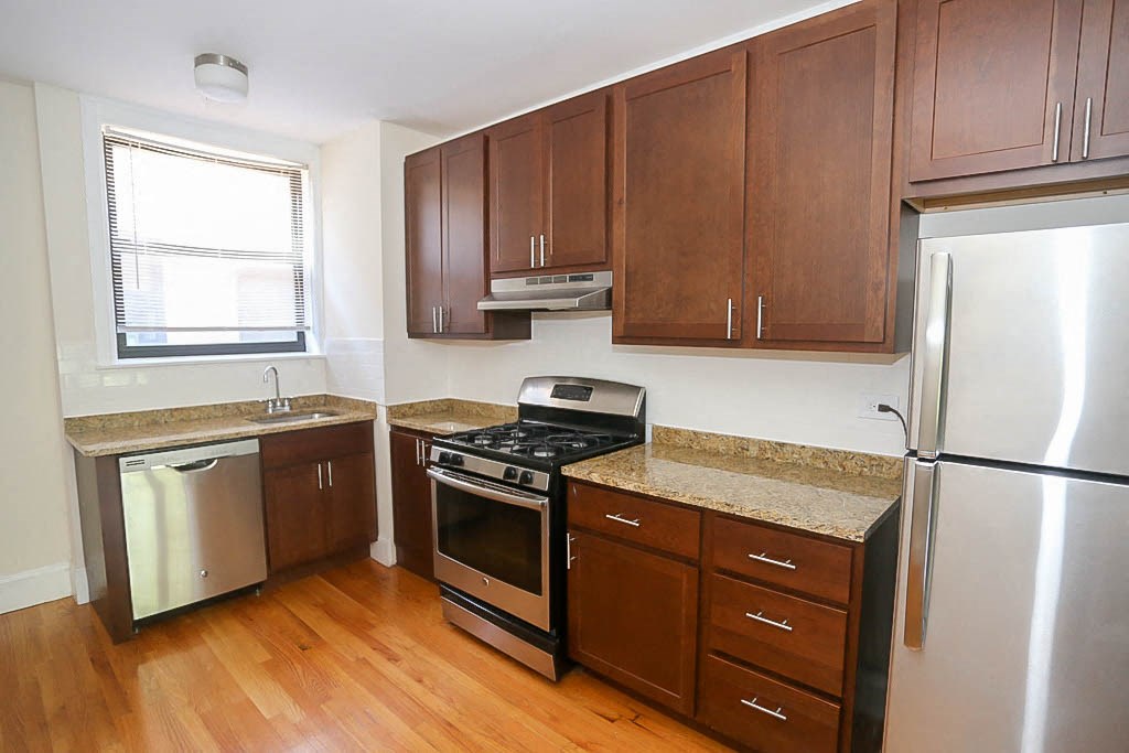 a kitchen with wooden floors and stainless steel appliances