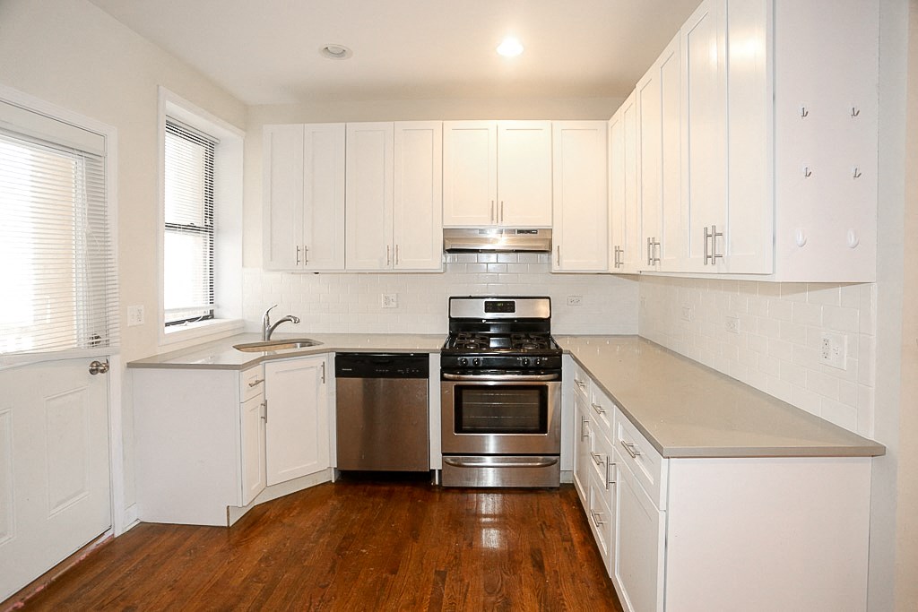 a kitchen with white cabinets and stainless steel appliances