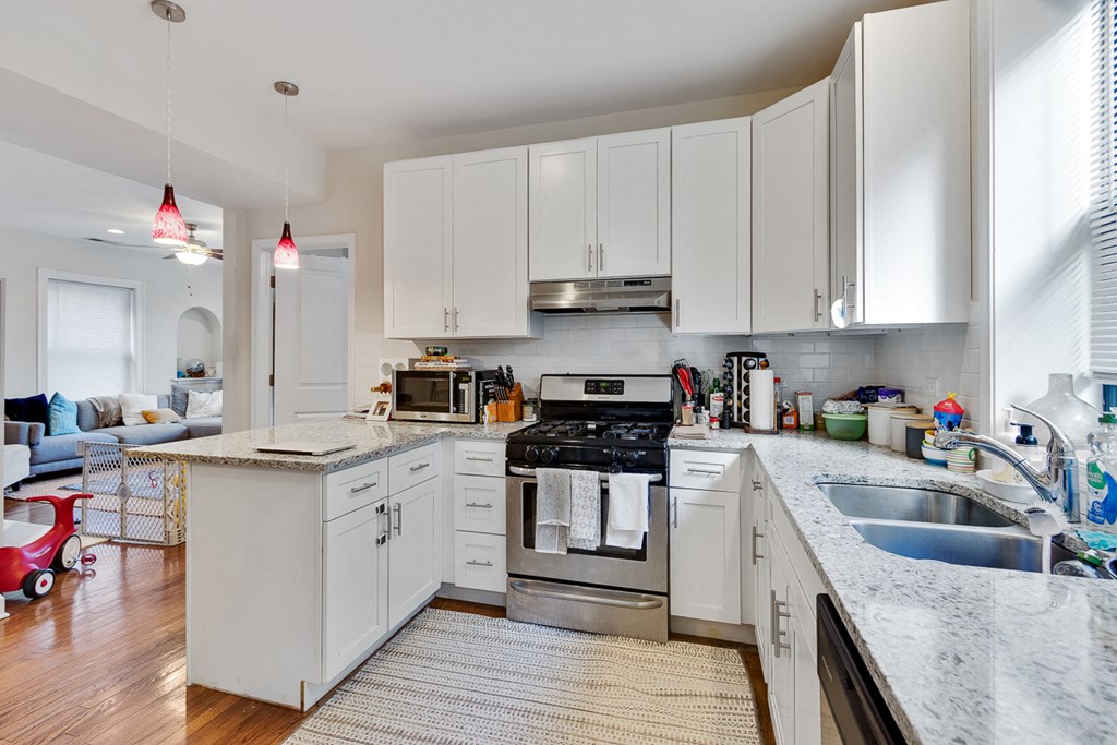 a kitchen with white cabinets and granite counter tops and a sink