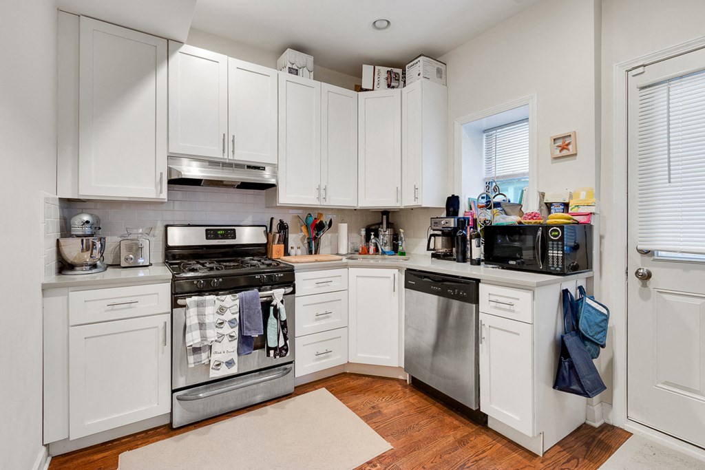 a kitchen with white cabinets and stainless steel appliances